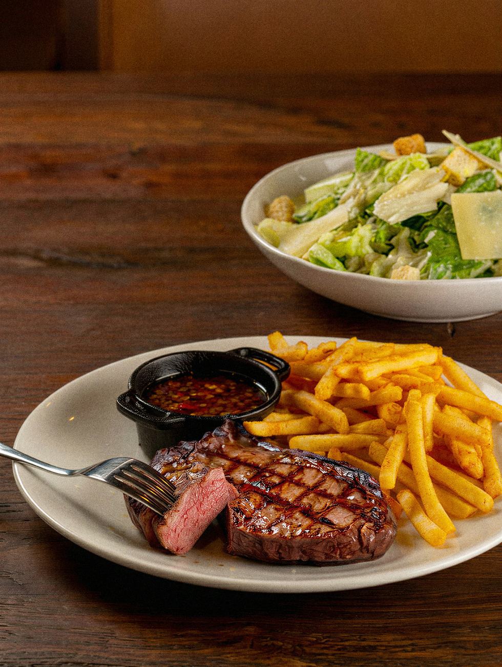 Corte na brasa com fritas e salada Caesar no salão
