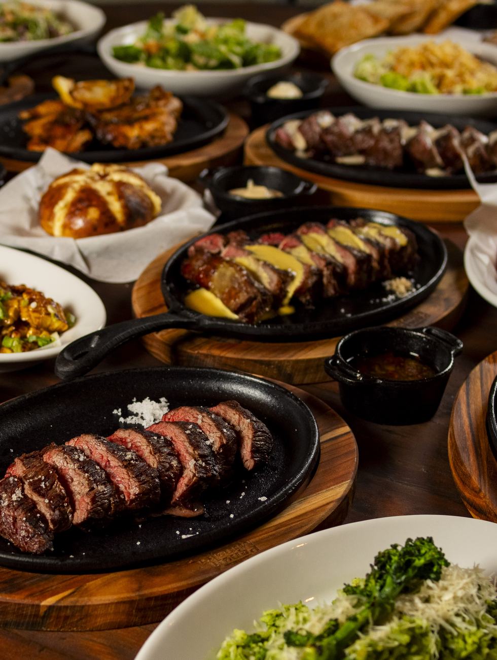 Mesa farta com cortes, acompanhamentos e molhos